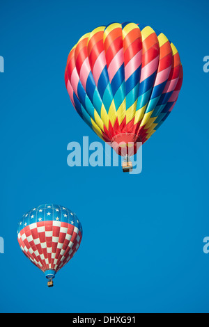 Una coppia delle colorate mongolfiere con un cielo sfondo blu Foto Stock