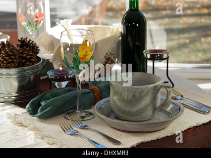 Pranzo informale messa in tavola, semplice e rustico con artistico bicchiere di vino e piatti in ceramica. Foto Stock