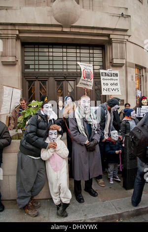 Londra, Regno Unito. Il 16 novembre 2013. I manifestanti che indossano maschere anonimo tenere premuto su cartelli e striscioni al di fuori di BBC Broadcasting House. I manifestanti sostengono che non vi è stata una mancanza di copertura di salvare il NHS e anti-austerità marche in BBC News la programmazione. In particolare la protesta nel settembre 2013 quando 60.000 persone hanno protestato contro i tagli per il NHS in Manchester. Credito: Pete Maclaine/Alamy Live News Foto Stock