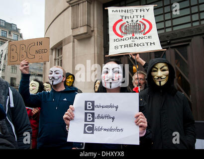 Londra, Regno Unito. Il 16 novembre 2013. I manifestanti che indossano maschere anonimo tenere premuto su cartelli e striscioni al di fuori di BBC Broadcasting House. I manifestanti sostengono che non vi è stata una mancanza di copertura di salvare il NHS e anti-austerità marche in BBC News la programmazione. In particolare la protesta nel settembre 2013 quando 60.000 persone hanno protestato contro i tagli per il NHS in Manchester. Credito: Pete Maclaine/Alamy Live News Foto Stock