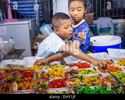 Bangkok, Tailandia. Xvi Nov, 2013. Bambini vende caramelle al Wat Saket Tempio fiera. Wat Saket è su un uomo fatto collina nella parte storica di Bangkok. Il tempio è golden guglia che è 260 metri di altezza che è stato il punto più alto di Bangkok per più di cento anni. Il tempio la costruzione iniziò nel 1800 durante il regno del Re Rama III e fu completata durante il regno del Re Rama IV. Il tempio annuale fiera si tiene il dodicesimo mese lunare, per nove giorni intorno al mese di novembre la luna piena. Credito: ZUMA Press, Inc./Alamy Live News Foto Stock