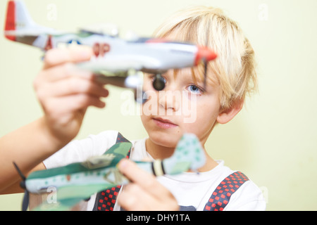 Bambino biondo ragazzo giocando - volare con la II guerra mondiale aerei fighters in plastica kit modello Foto Stock