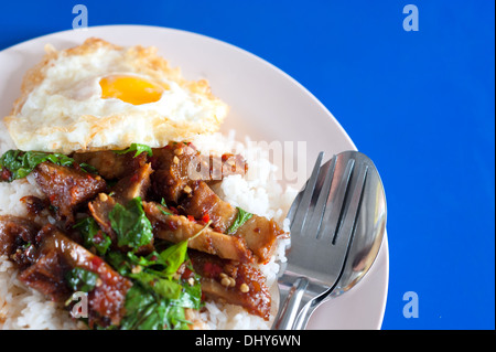 Riso con stir fritti caldi e carne di maiale piccante con basilico Foto Stock