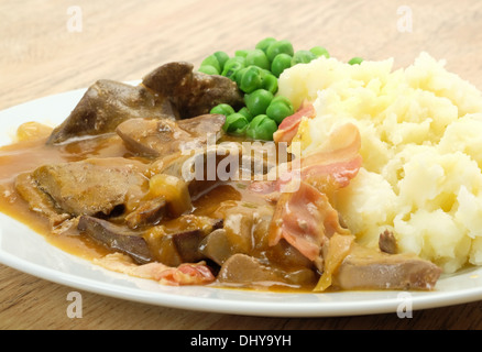 Classic British la cena del fegato e il bacon e servita con purea di patate, piselli e cipolla con sugo di carne - studio shot Foto Stock