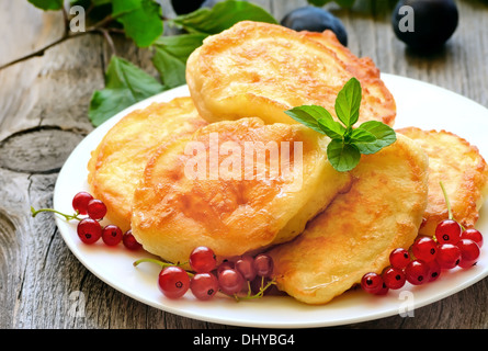 Frittelle decorate con rosse bacche Ribes sul tavolo di legno Foto Stock