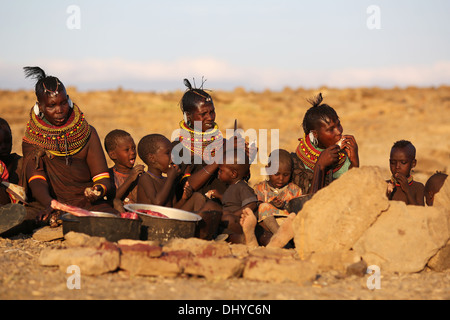 Turkana persone aventi una festa di capra, in remoto villaggio Turkana vicino a Loiyangalani, il lago Turkana in Kenya. Foto Stock