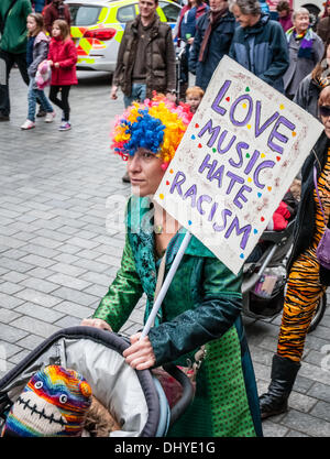 Donna con un "Amo la musica, odio il razzismo" spinge il suo bambino lungo durante la Exeter insieme marzo e diversità festival in Exeter Devon, Regno Unito Foto Stock