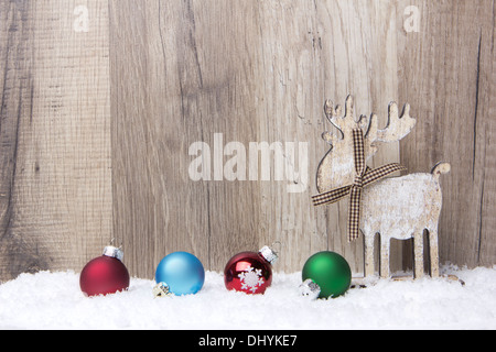 Decorazione di natale con uno sfondo di legno, neve elk e baubles di natale rosso, blu, verde Foto Stock