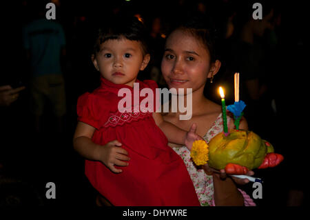 Bangkok, Tailandia. Xvii Nov, 2013. Madre tailandese w/ razza mista figlia (Thai - American) mantenendo le loro Krathong nel Parco di Benjasiri durante il Loy Krathong Festival, Bangkok, Thailandia. Loy Krathong (scritto anche come Loi krathong & noto come 'Il Festival della luce') si celebra ogni anno in tutta la Tailandia. Il nome potrebbe essere tradotto ''Corona flottante " o " Decorazione galleggiante'' e deriva dalla tradizione di produrre decorazioni galleggianti che vengono poi fatto galleggiare su un fiume. Credito: Kraig Lieb / Alamy Live News Foto Stock