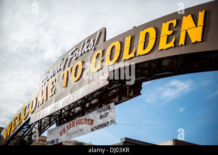 Benvenuto al Golden Arch Sign Colorado | GOLDEN, Colorado, Stati Uniti - visto dal basso, la gente di Howdy illuminata al neon! Benvenuto al Golden, dove l'arco della vita occidentale si estende su Washington Avenue nel centro di Golden. Dedicato nel 1949 e progettato dall'uomo pubblicitario di Coors Paul Reeves, il cartello in acciaio originariamente era scritto "Where the West Remains" (dove rimane l'Occidente) fino a quando un restauro del 1979 ha scambiato la parola finale con una con meno sfumature mortali. Foto Stock