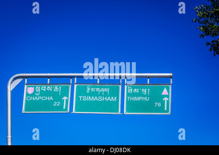 Cartello stradale sulla strada a Thimphu Bhutan contro il luminoso cielo blu Foto Stock