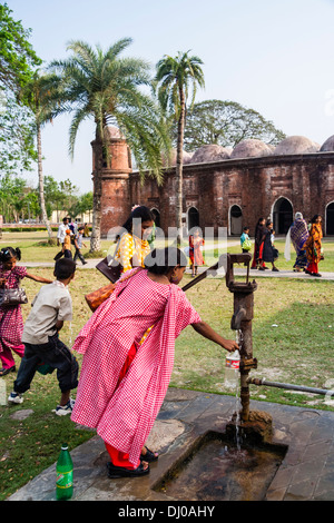 Persone a Shait Gumbad moschea, Bagerhat, Bangladesh il riempimento di bottiglie di acqua in corrispondenza di una vecchia pompa acqua Foto Stock