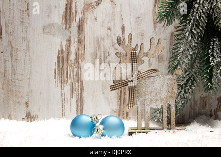 Decorazione di natale con uno sfondo di legno, neve elk, natale baubles blu e il ramo di abete Foto Stock