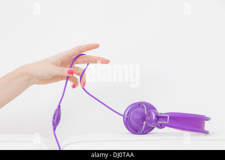 Donna sul divano con le cuffie Foto Stock