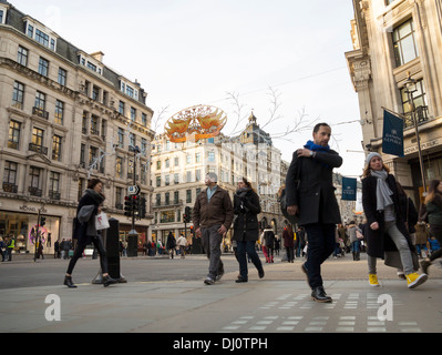 Christmas Shopper sono su Regent Street sotto le decorazioni di Natale. Foto Stock