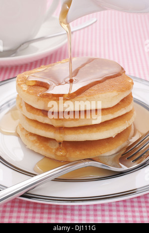 Versare lo sciroppo di acero sulle frittelle latticello Foto Stock