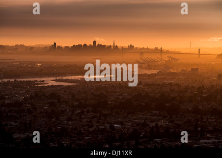 Vista dal centro cittadino di Oakland, la California di San Francisco con il Bay Bridge e il Golden Gate Bridge al tramonto Foto Stock
