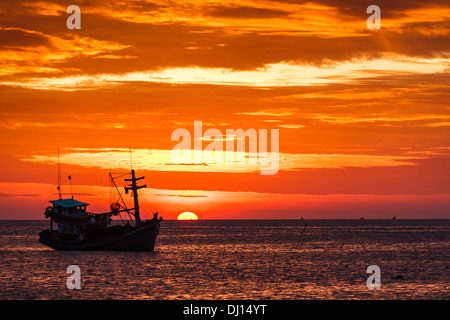 Naufragio di sole sulla linea di orizzonte sagome barca da pesca nel cielo arancione sull'isola di Phu Quoc Vietnam asia Foto Stock