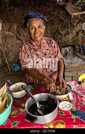 Un anziano zapoteco donna indigena mano rende i tamales tradizionali per l'uso nel giorno dei morti festival noto in spagnolo come Día de Muertos Ottobre 30, 2013 in Teotitlan, Messico. Foto Stock