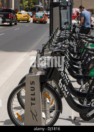 Toronto Bixi bike. Una fila di Bixi nero il noleggio biciclette in affitto la loro sorge su una trafficata Downtown Toronto street. Foto Stock