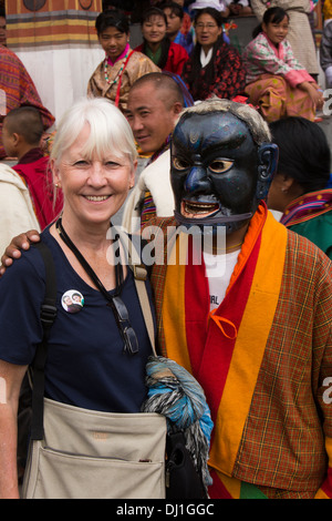 Il Bhutan, Thimpu Dzong, Tsechu annuale senior donna occidentale turistico con atsara clown Foto Stock