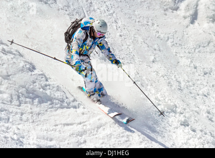 L'uomo sciatore su un ripido pendio di montagna Foto Stock