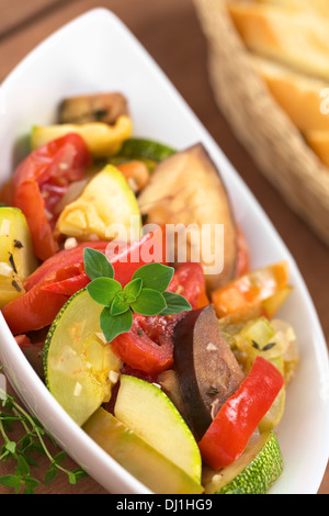 Ciotola di freschi fatti in casa fatta Ratatouille di melanzane, zucchine, peperoni e pomodori e condita con erbe aromatiche Foto Stock