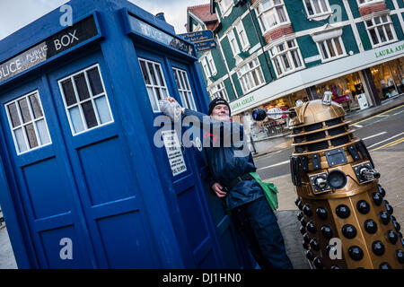 Aberystwyth Wales UK. Martedì 19 Novembre 2013 come parte del Dr Who cinquantesimo anniversario, il tardis è su un tour a sorpresa di welsh cittadine e città. Arresto in Aberystwyth iconica casella di polizia è stato affiancato da un DALEK E K-9 compagni di stelle della lunga esecuzione di culto programma televisivo della BBC. NIGEL pulisce BOWDEN il tardis finestra sotto l'occhio vigile del DALEK phot Credit: keith morris/Alamy Live News Foto Stock