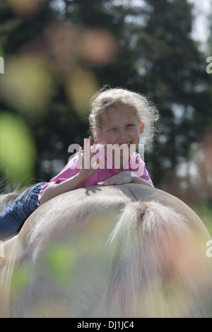 Sorridente ragazza distesa groppa fiordo norvegese cavallo Foto Stock