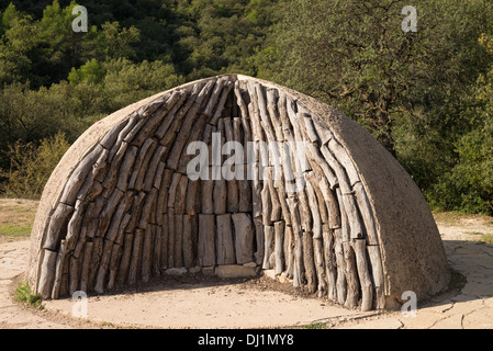 Logs impilati in un tradizionale carbone forno Foto Stock