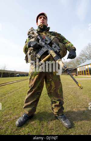 Un mimetizzata soldato con la sua arma automatica è pronta per un corso di formazione delle forze speciali in un freddo giorno Foto Stock