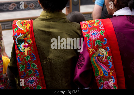 Il Bhutan, Thimpu Dzong, Tsechu annuale, donne che indossano colorati infissi ricamato Foto Stock