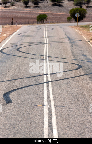 Burn Out auto tracce di pneumatici sulla strada da spiinning ruote vettura, Murchison Australia Occidentale Foto Stock