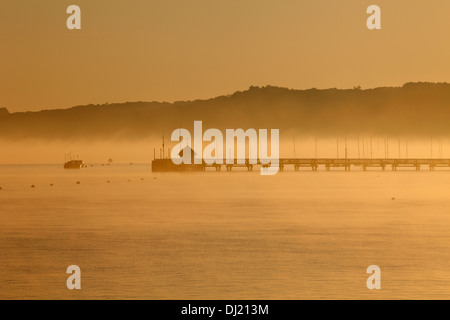 Yarmouth Pier e il mare di Yarmouth in early morning light foschia marina Yarmouth Isle of Wight Hampshire Inghilterra Foto Stock