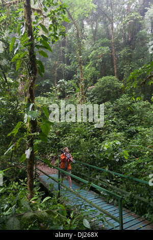 Una donna a piedi attraverso la Monteverde Cloud Forest Riserve in Costa Rica. Foto Stock