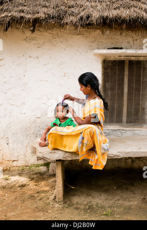 Madre indiana la sua pettinatura giovani figlie i capelli in una zona rurale villaggio indiano. Andhra Pradesh, India Foto Stock