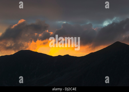 Bel colore arancione del sole sopra le montagne, Monti Fagaras, Romania Foto Stock