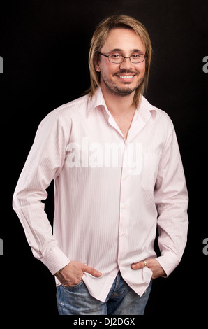 Ritratto di bel giovane uomo sorridente su sfondo nero Foto Stock