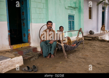 Famiglia indiana con il bambino in una culla di fatti in casa in una zona rurale villaggio indiano. Andhra Pradesh, India Foto Stock