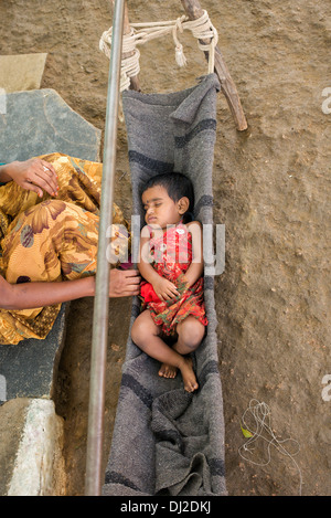Indian Baby girl dormire in una culla di fatti in casa in una zona rurale villaggio indiano. Andhra Pradesh, India Foto Stock