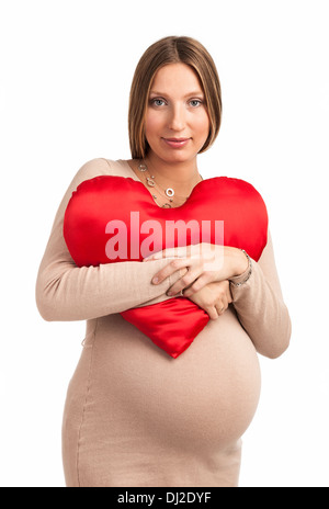 Sorridente donna incinta con cuore Cuscino sagomato su bianco Foto Stock