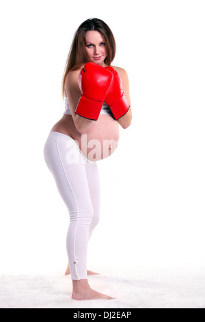 Giovane donna incinta indossando un paio di guanti da boxe Foto Stock