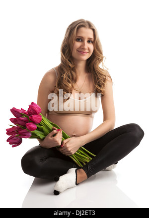 Felice giovane donna incinta fiori di contenimento Foto Stock