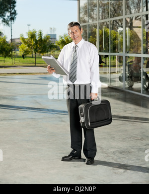 Fiducioso Maestro con la borsa per notebook e libri in piedi sul College Foto Stock