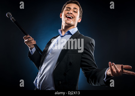 Uomo in elegante giacca nera tenendo la canna da zucchero Foto Stock
