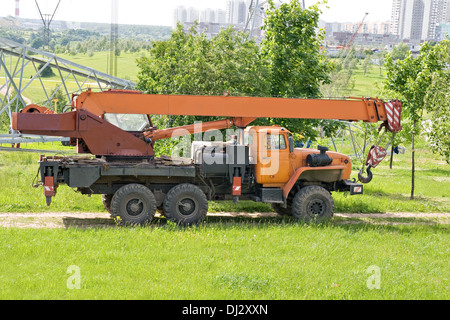 Un arancio carrello gru in piedi in un parco della città Foto Stock