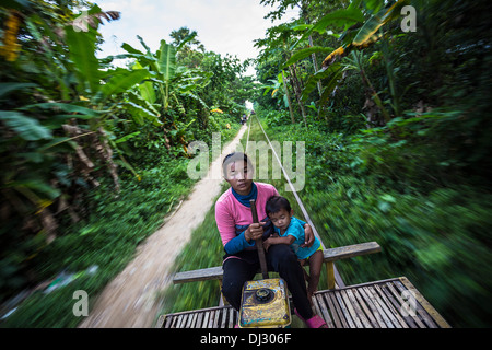 La madre e il bambino la guida del treno di bambù di Battambang, Cambogia. Foto Stock