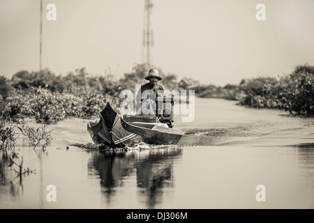 Un pescatore in uno dei piccoli corsi d'acqua sul lago Tonle Sap in Cambogia. Foto Stock