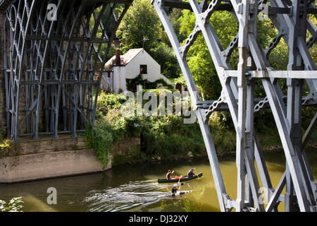 Canoisti + kayaker di passare sotto il ponte di ferro sul fiume Severn a (Ironbridge Gorge), Shropshire, West Midlands, England, Regno Unito Foto Stock