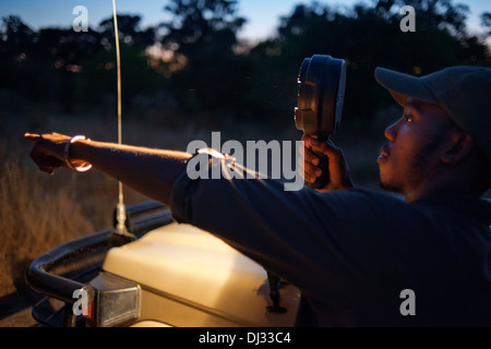La guida viene fornita con un potente torcia elettrica con guardando gli animali durante il safari notturno Orient Express esegue. Foto Stock
